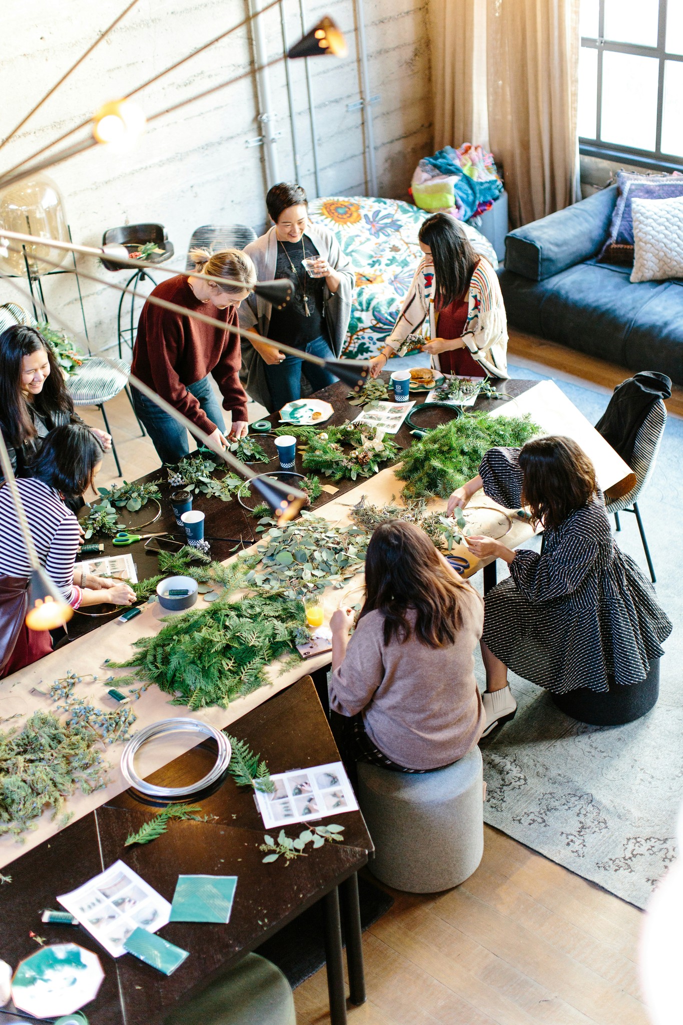 women crafting with greenery at workshop table